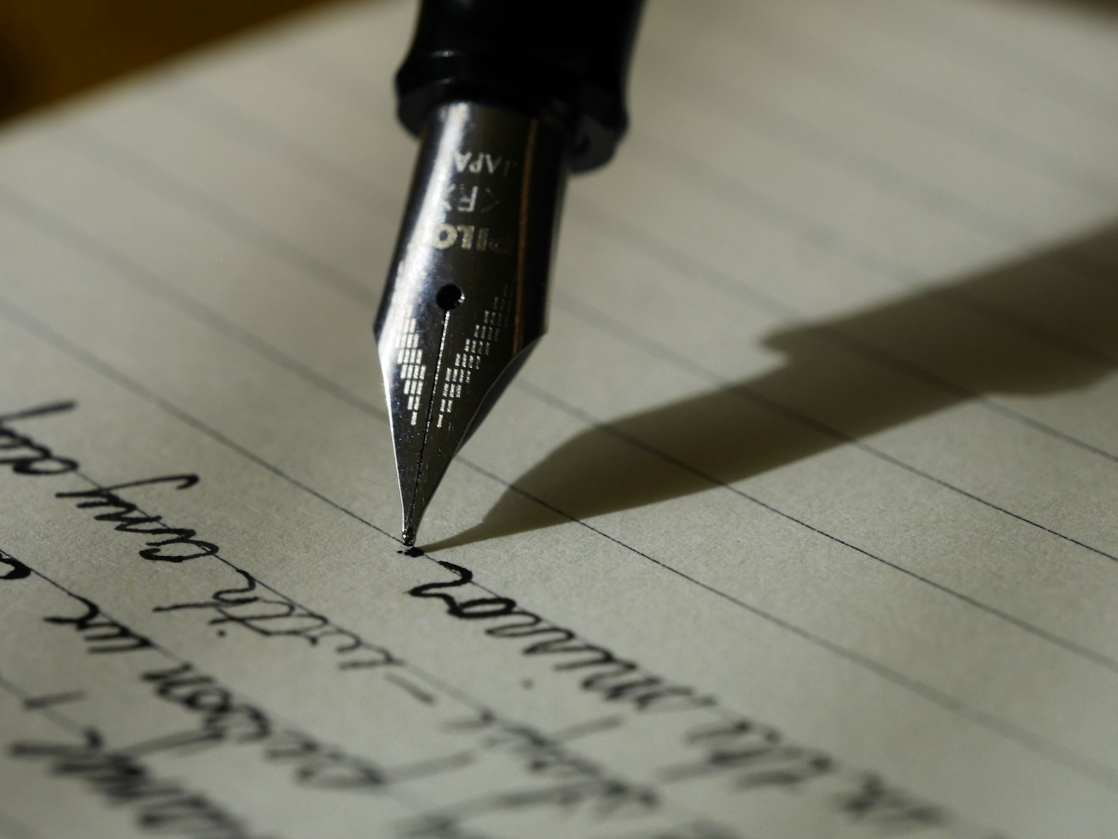 Een vulpen schrijft met de hand op gelinieerd papier.