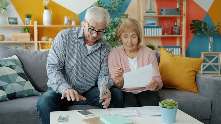 Een ouder echtpaar op de bank leest samen een brief.