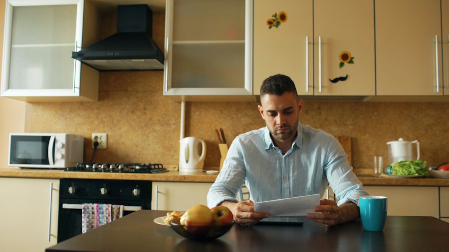 Een man leest aan de keukentafel een brief.